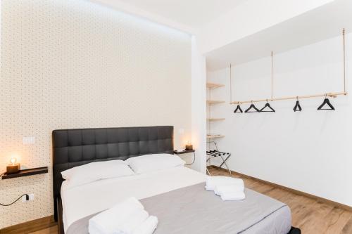 a bedroom with a bed and a white wall at Pietramare Luxury Suites in Bari