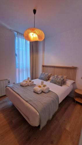 a bedroom with a large bed with towels on it at Apartamentos Puerto Camariñas in Camariñas