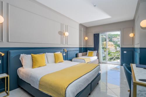 a blue and white bedroom with a bed with yellow pillows at Hotel Mary in Vico Equense