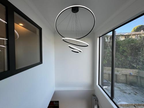 a room with a window and a pendant light at NO PARTY ALLOWED, Entire Brand New 3 bedroom townhouse, free unlimited fibre wifi and free parking in Wellington