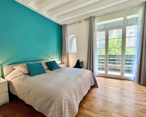 une chambre avec un grand lit avec un mur bleu dans l'établissement R'Apparts T3 Le Prestige Grenoblois, à Grenoble
