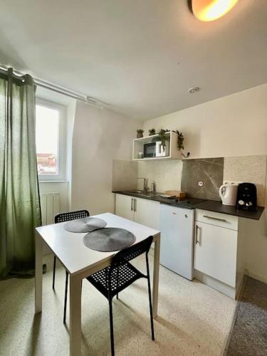 - une cuisine avec une table, une table et des chaises dans l'établissement Studio 4 Rue Théodore Bac - DABNB, à Limoges