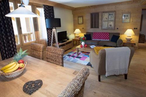 un salon avec un canapé et une table dans l'établissement L'Aquila 23 - 2 bedroom apartment on the piste, à Val dʼIsère