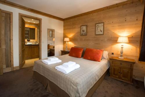 une chambre avec un lit avec deux serviettes dessus dans l'établissement L'Aquila 23 - 2 bedroom apartment on the piste, à Val dʼIsère