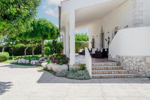 a white house with stairs and flowers and trees at Pietramare Luxury Suites in Bari