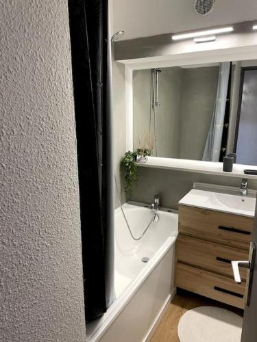 une salle de bain avec une baignoire, un lavabo et un miroir dans l'établissement Charmant studio proche de la mer, à Antibes