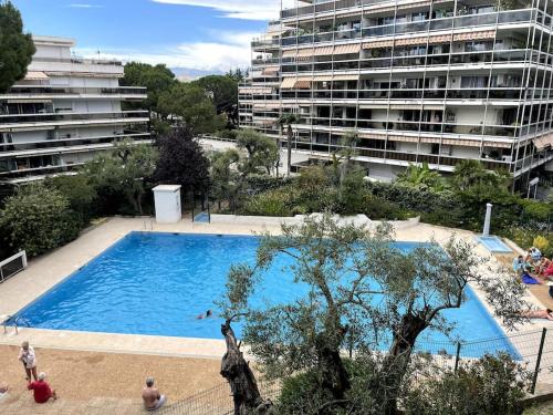 une grande piscine en face d'un grand bâtiment dans l'établissement Charmant studio proche de la mer, à Antibes