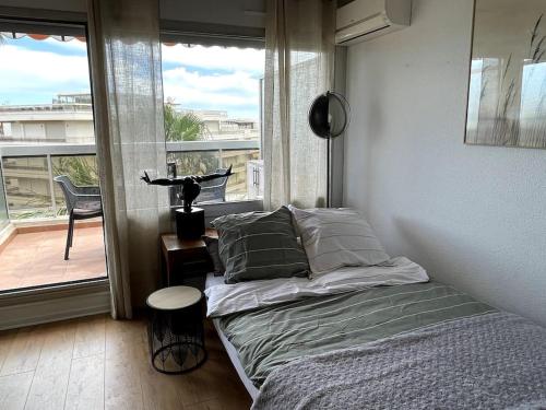 une chambre avec un lit et une vue sur un balcon dans l'établissement Charmant studio proche de la mer, à Antibes