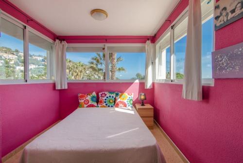 a pink bedroom with a bed with a pink wall at Club Villamar - Issei in Blanes