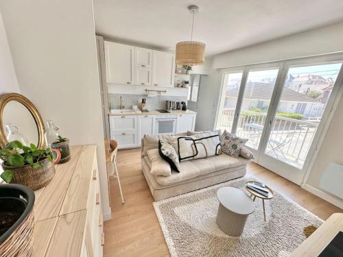 un salon avec un canapé et une cuisine dans l'établissement Appart avec Balcon et Place de Parking à Berck-Plage, à Berck-sur-Mer