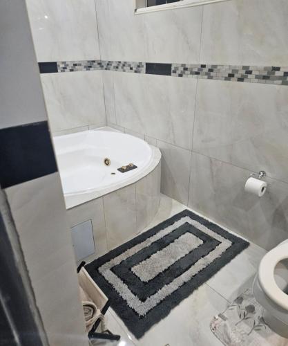 a bathroom with a tub and a sink and a toilet at The Royal Princess B&B on Malibongwe Drive in Johannesburg