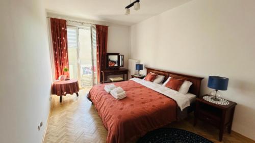 a bedroom with a bed with a red comforter at Apartament Rodzinny Nad Morzem, Gdynia in Gdynia