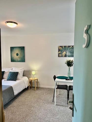 une chambre blanche avec un lit et une table dans l'établissement Studio 5 Rue Théodore Bac - DABNB, à Limoges