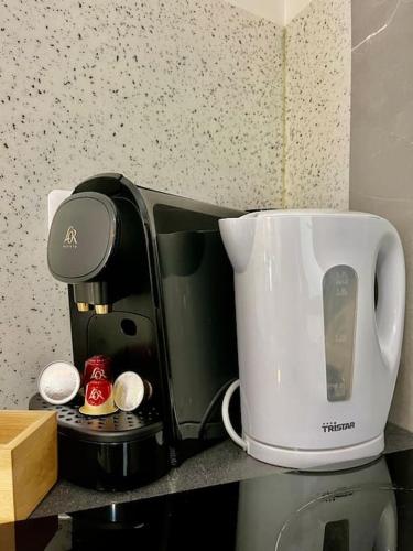 - une cafetière installée au-dessus d'un comptoir de cuisine dans l'établissement Studio 5 Rue Théodore Bac - DABNB, à Limoges