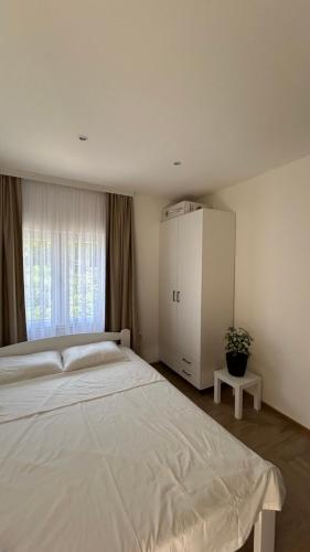 a bedroom with a large bed and a white cabinet at Apartmani Radmanovic in Tivat