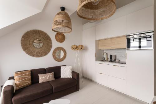 un salon avec un canapé marron et une cuisine dans l'établissement Ty Peskaiden 2 - Appt vue mer à Cancale, à Cancale