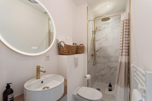 une salle de bain avec un lavabo, des toilettes et un miroir dans l'établissement Ty Peskaiden 2 - Appt vue mer à Cancale, à Cancale