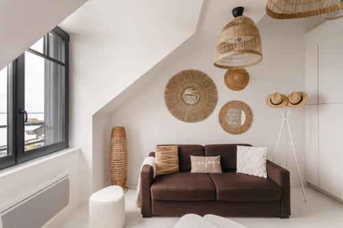 un salon avec un canapé marron et une fenêtre dans l'établissement Ty Peskaiden 2 - Appt vue mer à Cancale, à Cancale
