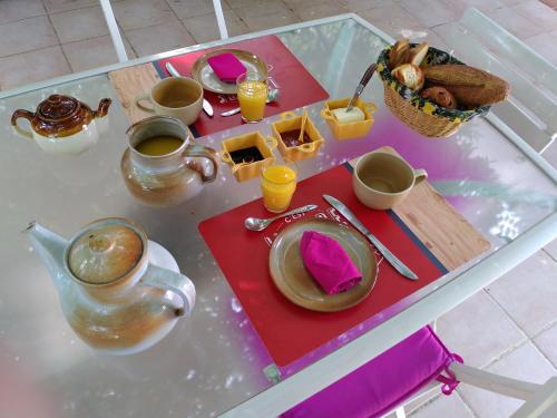 une table avec une assiette de nourriture et une tasse de café dans l'établissement Au nid de mes Anges, à Entrecasteaux
