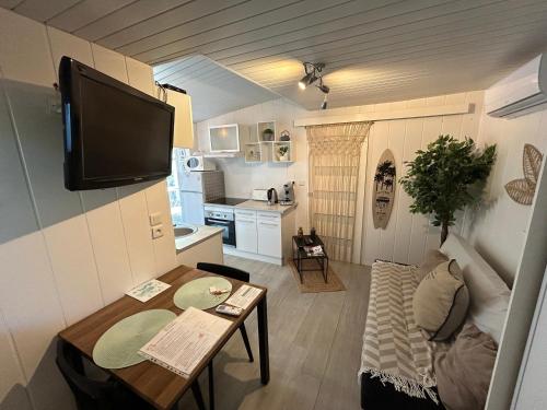 Il comprend un petit salon avec une table et une cuisine. dans l'établissement Maison MAHECO, à Gujan-Mestras