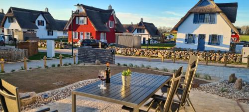 a wooden table with a bottle of wine and chairs at neben Wismar FH"FaJuKa" Strandnah mit Wallbox in Zierow