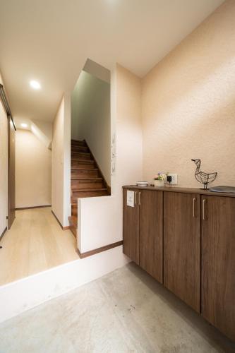 a room with a staircase and a kitchen with wooden cabinets at 22, Itabashi, Entire house for rent, 板橋 in Tokyo