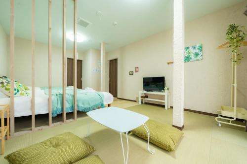 a bedroom with a bed and a table and a tv at 22, Itabashi, Entire house for rent, 板橋 in Tokyo