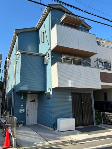 a blue building on a street with an orange cone at Lapis House 201 - 2F & 3F in Tokyo