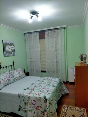 a bedroom with a bed and a ceiling fan at El rinconcito de Aldán in Aldán