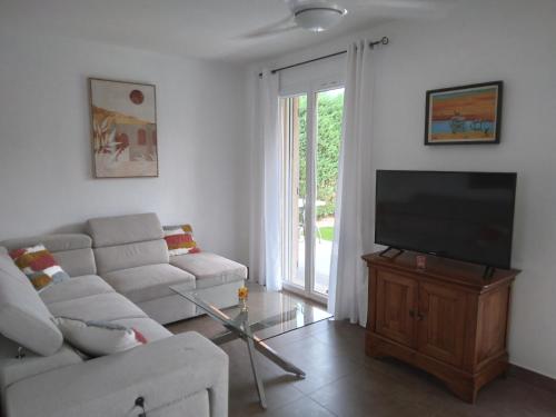 a living room with a couch and a flat screen tv at L'Orinaju in Oletta