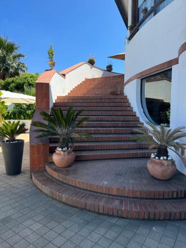 a set of stairs with potted plants in front of a building at Il Caimano B & B, con piscina dall'11 Luglio al 31 Agosto in Vulcano