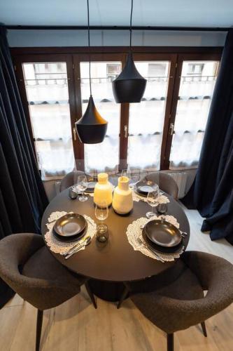 a dining room table with two chairs and a table with glasses at El Bosque Del Puerto in Gijón