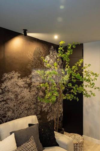 a living room with a couch and a tree at El Bosque Del Puerto in Gijón