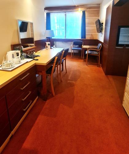 a kitchen with a table and chairs and a desk at Hotel 365 in Kielce