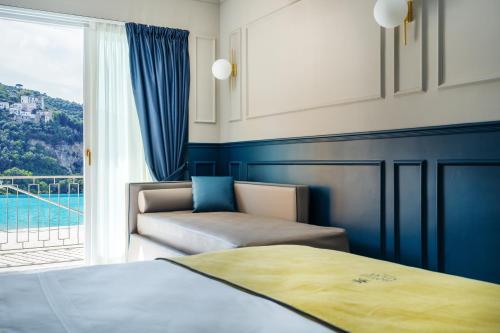 a bedroom with a bed and a couch and a window at Hotel Mary in Vico Equense