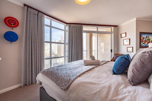 a bedroom with a large bed with a large window at Luxury Ocean View Beachfront 2 bed apartment -206 The Waves, Blouberg, Cape Town in Bloubergstrand
