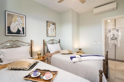 a bedroom with two beds with hats and a tray on it at Lampetos Houses Molyvos in Mithymna