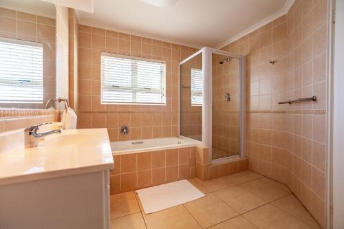 a bathroom with a shower and a sink at Luxury Ocean View Beachfront 2 bed apartment -206 The Waves, Blouberg, Cape Town in Bloubergstrand