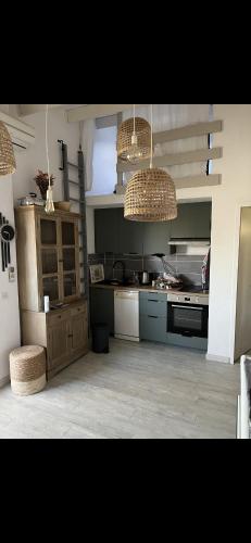 une cuisine avec deux lustres et un comptoir dans une pièce dans l'établissement Cosystcyp, à Saint-Cyprien