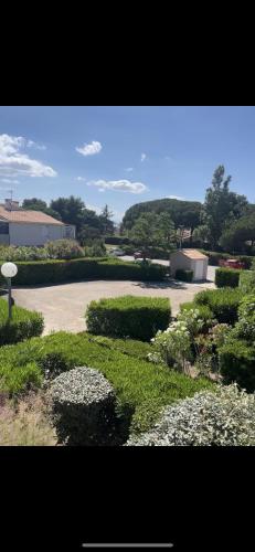 un jardin avec des fleurs blanches et un parking dans l'établissement Cosystcyp, à Saint-Cyprien
