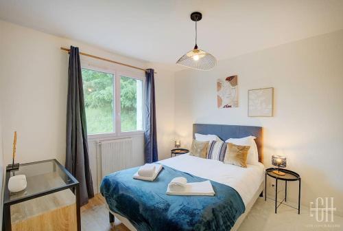 a bedroom with a bed with two towels on it at Plumeria - A 2min de Tours in Tours