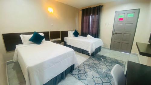 a hotel room with two beds and a window at Motel Seri Mutiara in Kuah