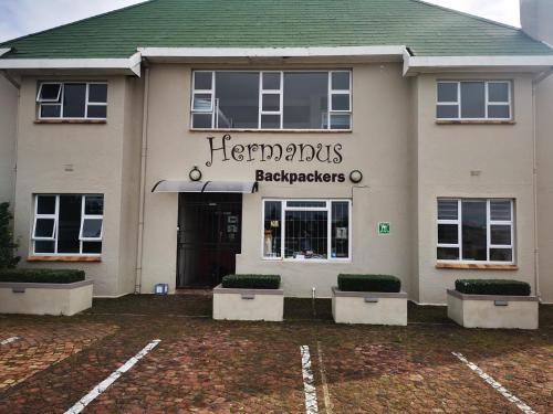 een winkel voor een gebouw met een bord erop bij Hermanus Backpackers & Budget Accommodation in Hermanus