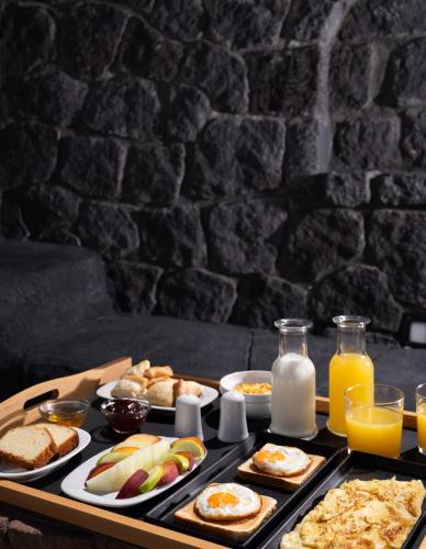 un vassoio per la colazione con cibi per la colazione e latte su un tavolo di Griseo Villas a Karterados