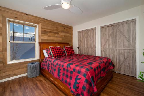 a bedroom with a bed with a red plaid blanket at Waterside West A303 in Fraser