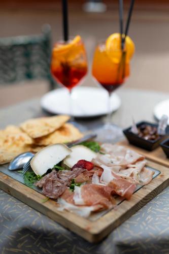 a cutting board with meat and cheese and a drink at Hotel Hiberia in Rome