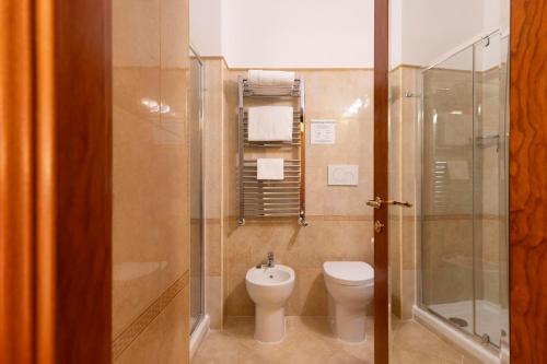 a bathroom with a toilet and a glass shower at Hotel Hiberia in Rome