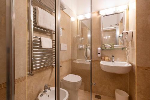 a bathroom with a toilet and a sink and a shower at Hotel Hiberia in Rome