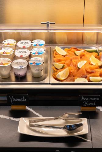 a buffet with a tray of food and a pair of scissors at Hôtel Spa Restaurant Villa Castellane in Gréoux-les-Bains