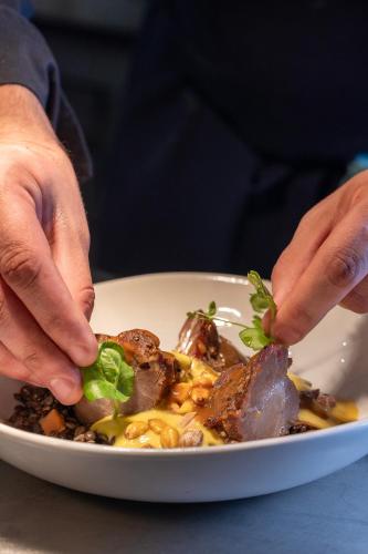 a person is preparing a plate of food at Hôtel Spa Restaurant Villa Castellane in Gréoux-les-Bains